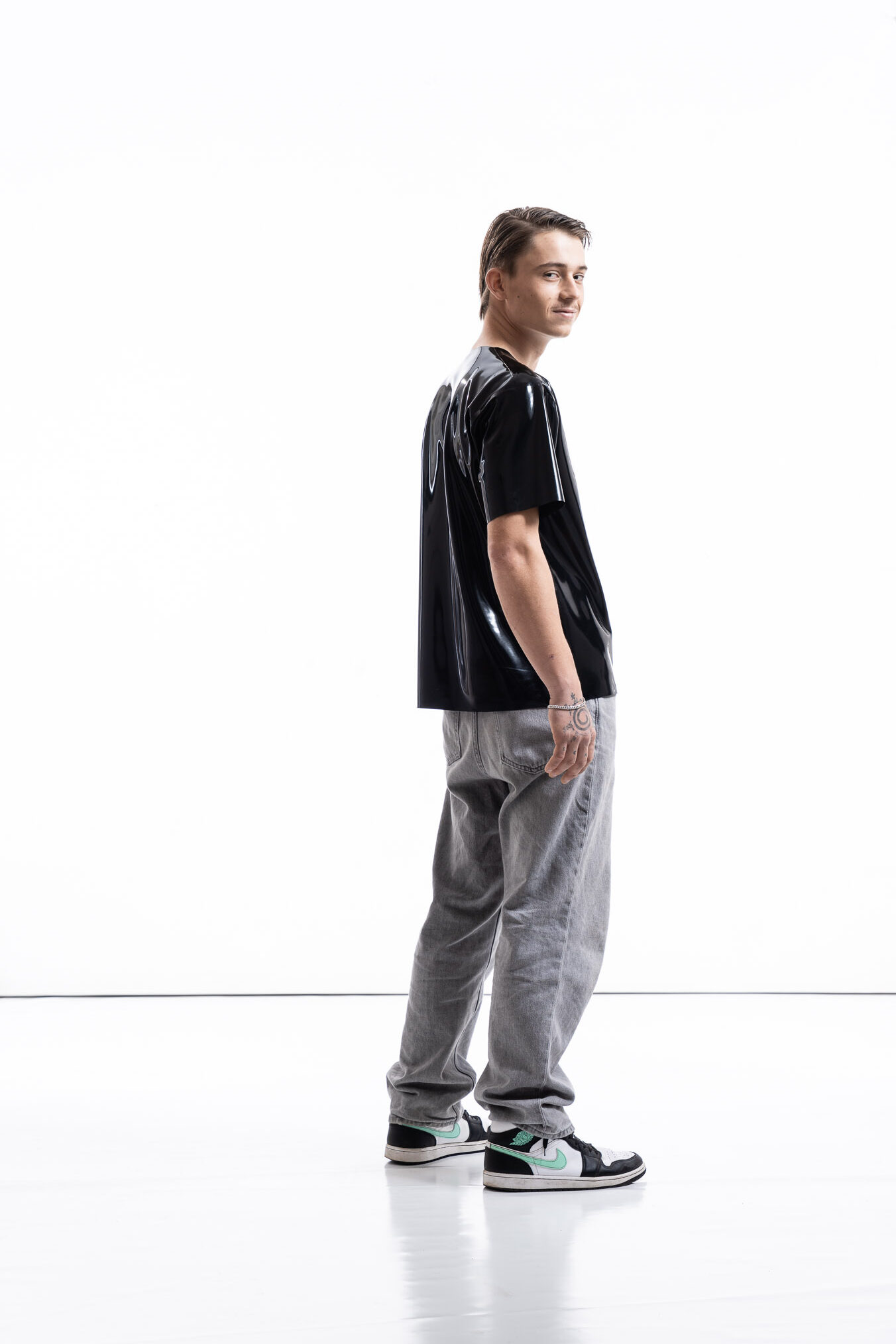 Black latex oversized shirt for men with relaxed silhouette, side view