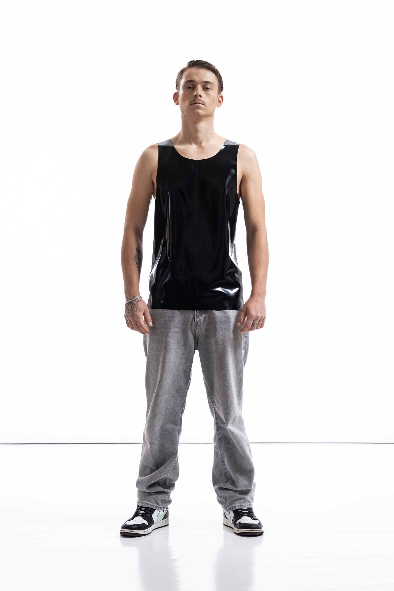 Black latex tank top for men with relaxed silhouette, front detail view